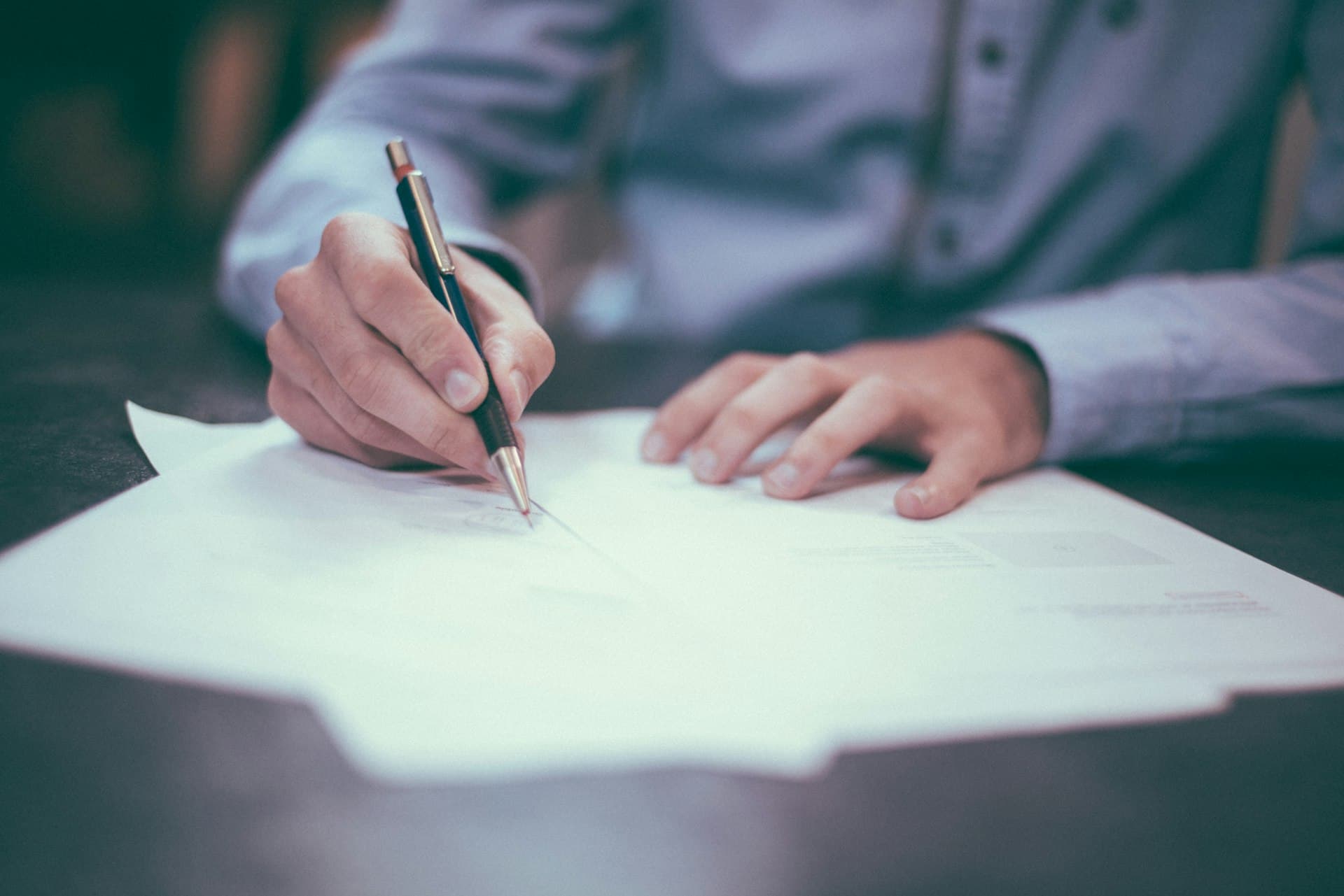 A hand signing a legal document